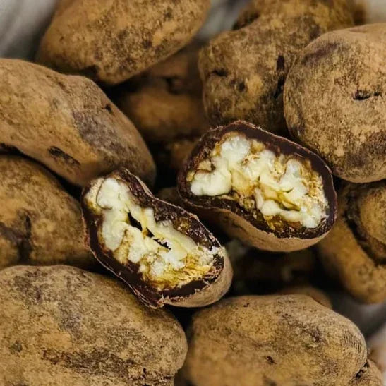 Chocolate-covered walnuts with dark textured coating and creamy white interior, The Organic House Chocolate Coated Spicy Candied Pecans