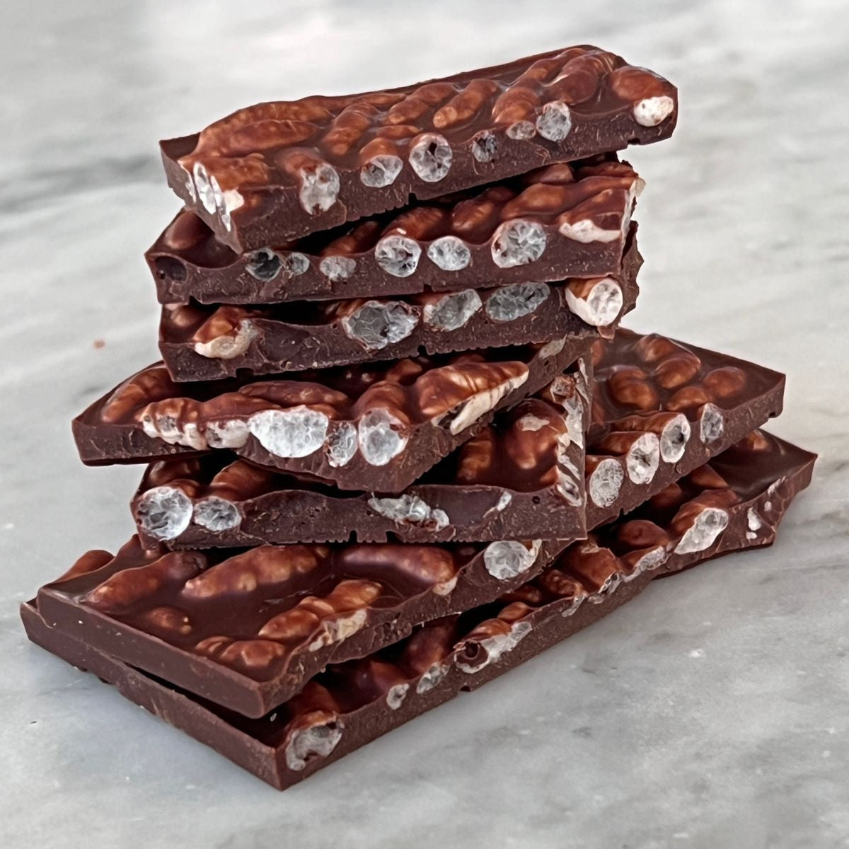 Mirzam Mango Sticky Rice Milk Chocolate 52% bar stack with nuts and candy