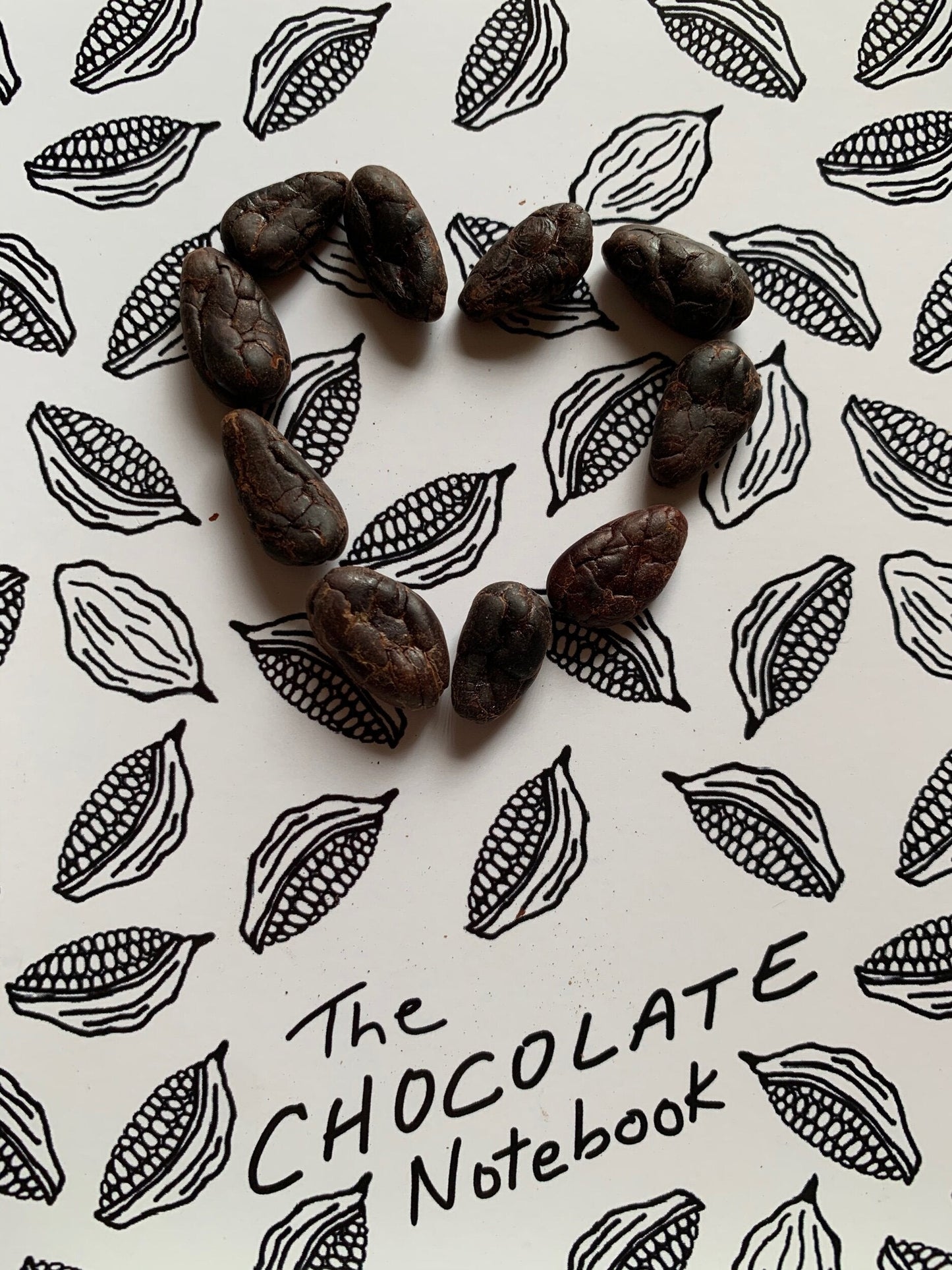Dark brown textured cacao beans in heart shape for The Chocolate Notebook