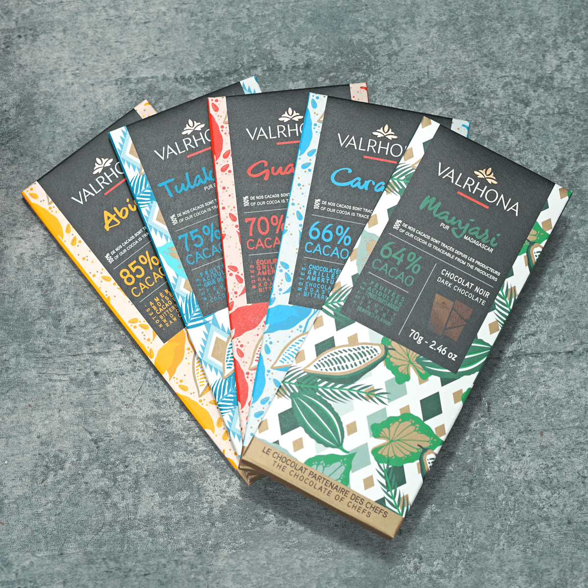 Five wrapped Valrhona dark chocolate bars, including Manjari 64% and Abinao 85%.