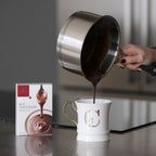 White ceramic Domori Hot Chocolate mug with gold handle and silver C monogram