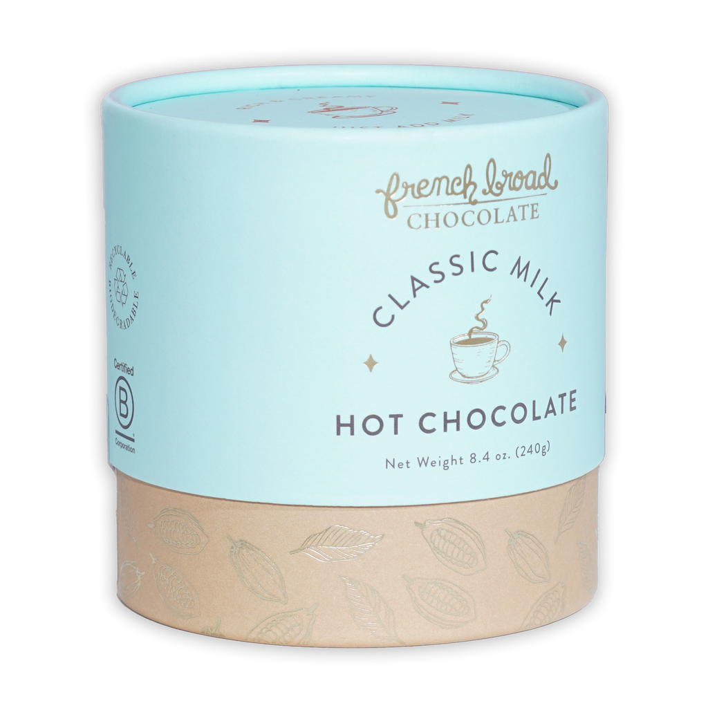 French Broad Milk Hot Chocolate Mix in light blue cylindrical can with beige base and gold leaf patterns