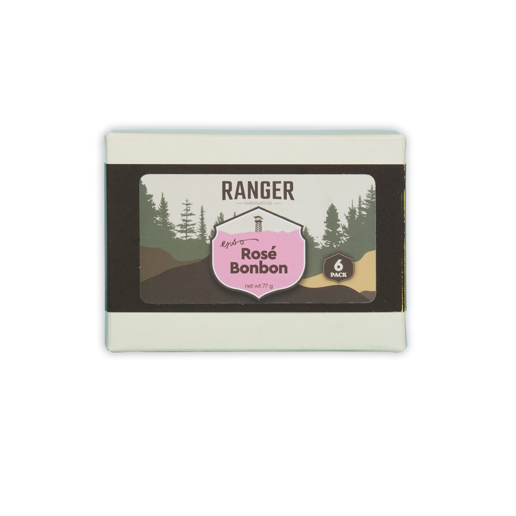 Ranger rosé bonbons box with six pink and brown candies in a white rectangular box featuring forest imagery