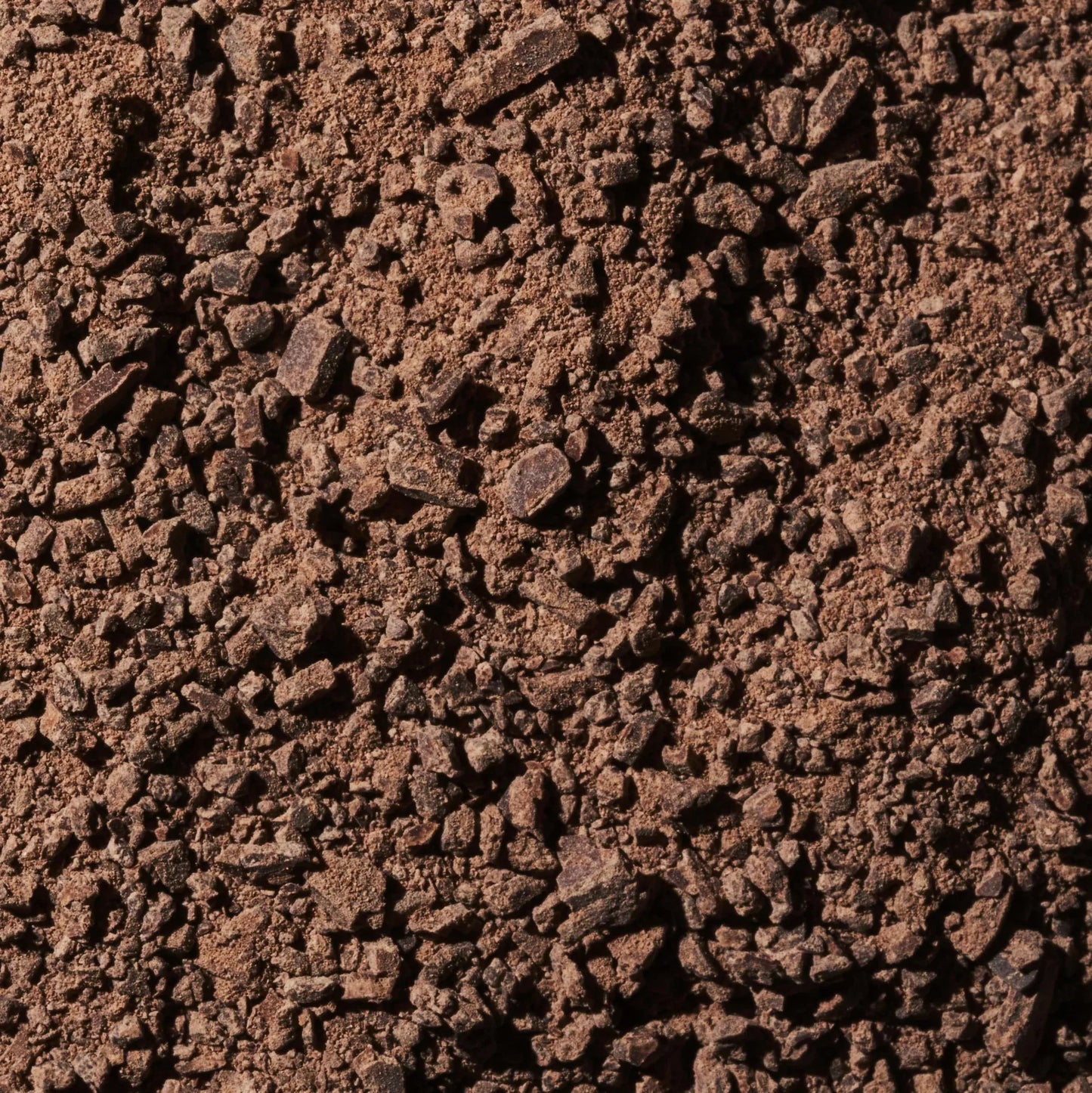 Dark brown coarse coffee grounds in Ritual Mid Mountain 65% chocolate