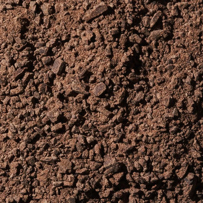 Dark brown coarse coffee grounds in Ritual Mid Mountain 65% chocolate