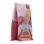 A vibrant pink and white bag of ariana’s cozy cabin blend ritual drinking chocolate 55 percent with geometric orange accents