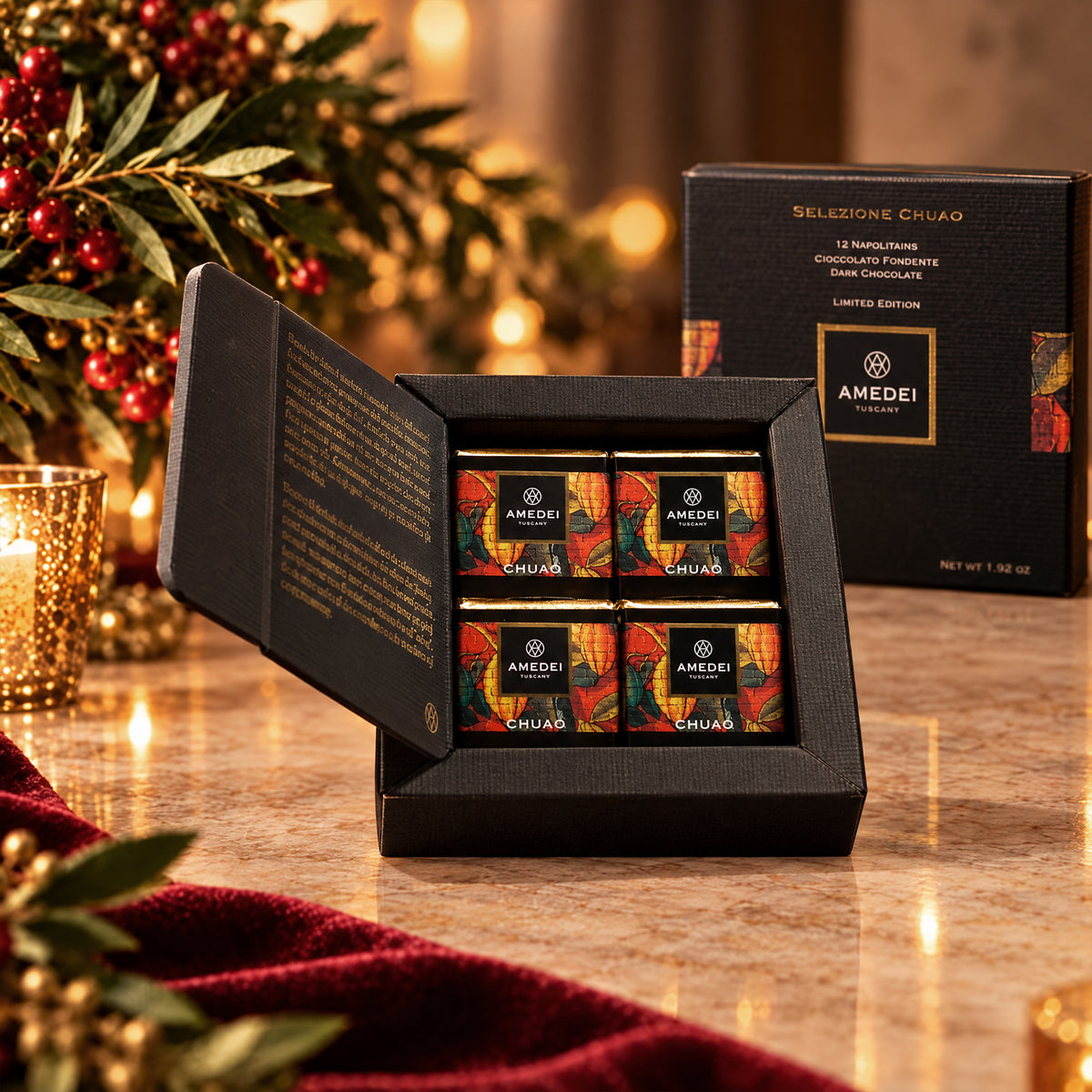 Open Amedei box of 12 individually wrapped Chuao 70% dark chocolate napolitains, with holiday greenery.