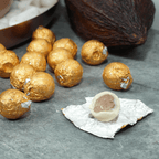 Amedei Pralines White w/ Hazelnut Filling: golden foil-wrapped truffles, one unwrapped showing white shell and dark center