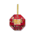 A red and gold faceted ornament box of Auro Hot Milk Chocolate Bomb with a gold ribbon loop on a black background.