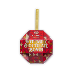 A red and gold faceted ornament box of Auro Hot Milk Chocolate Bomb with a gold ribbon loop on a black background.