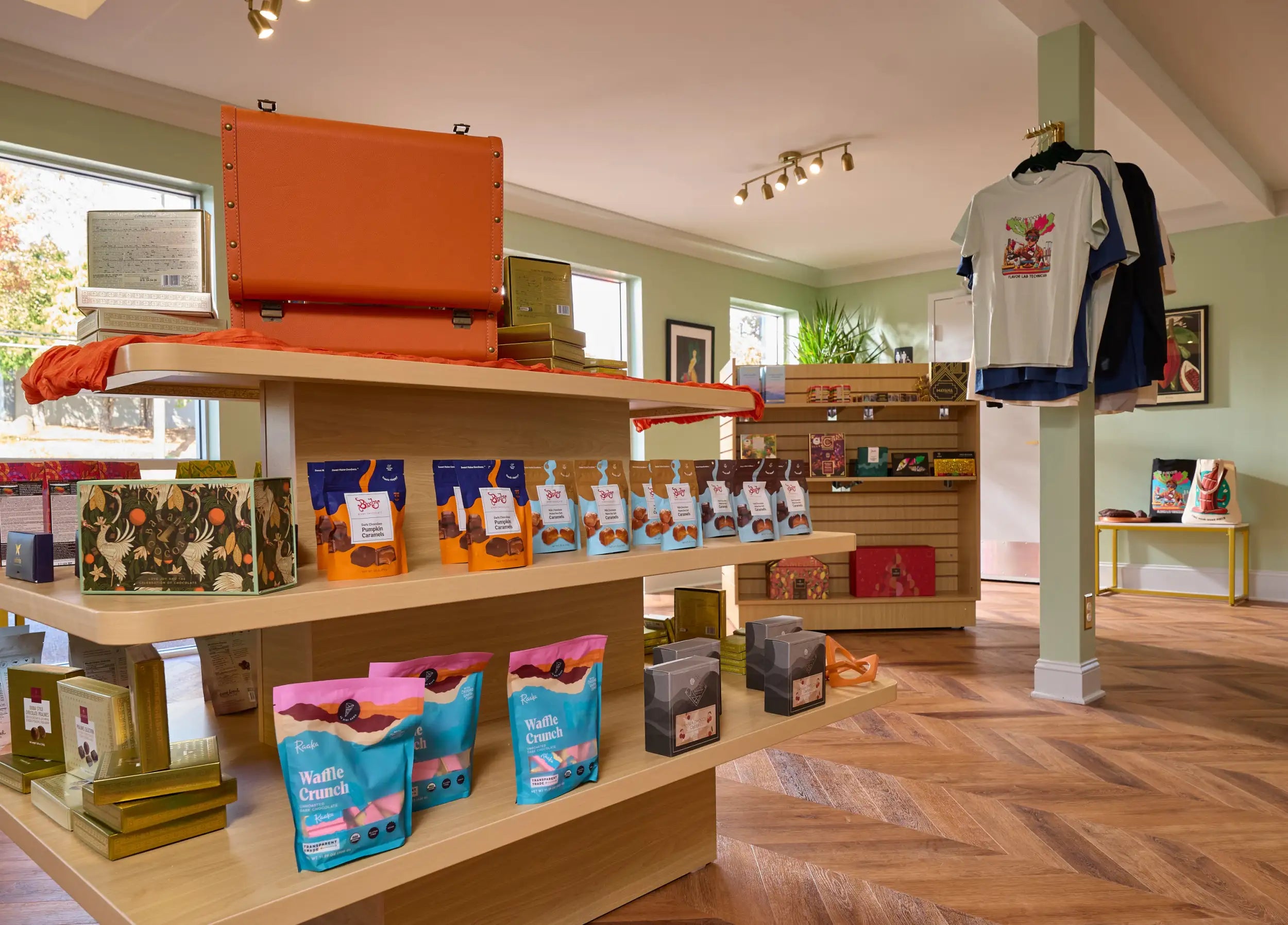 Orange leather suitcase with brass hardware displayed on a wooden shelf