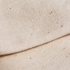 Beige canvas eco tote bag fabric with woven texture and dark specks