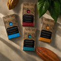 Four Chocolarder bars with cacao pods: Öko Caribe 60%, Cinnamon Toasted Cacao Nibs 74%, Ashaninka 72%, Cornish Honeycomb 50%
