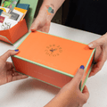 Vibrant orange Chocolate Bars of the World Gift Box with mint green trim and gold foil branding