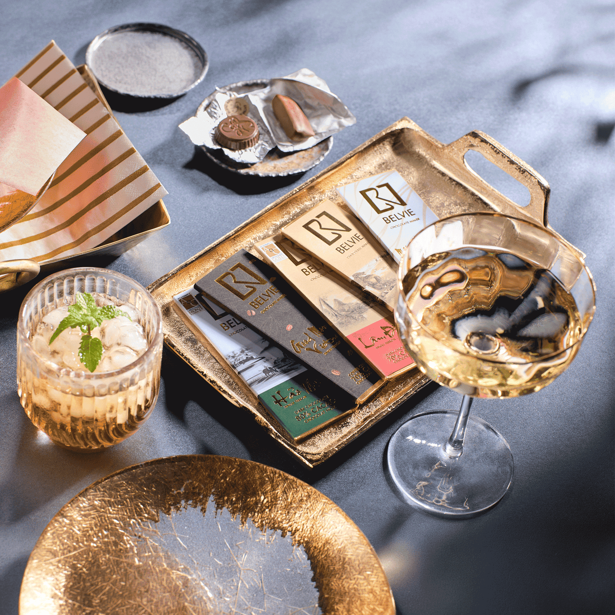 Belvie mini chocolate bars on a gold tray with sparkling wine