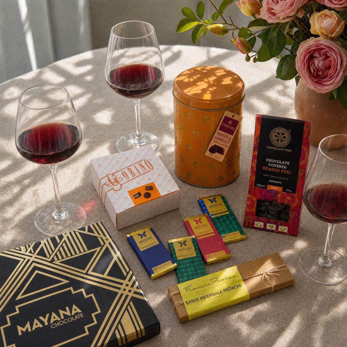 Dinner Party Hero chocolate gift bundle, boxes, a tin and bars with red wine.
