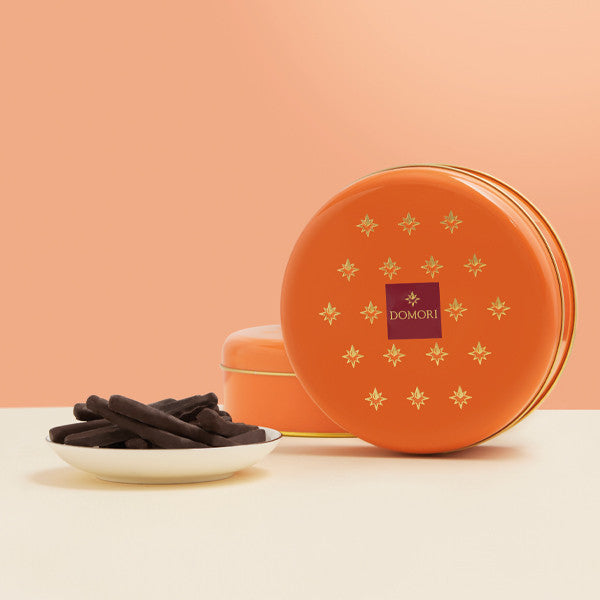 Domori orange tin with gold stars, purple logo, dark chocolate sticks
