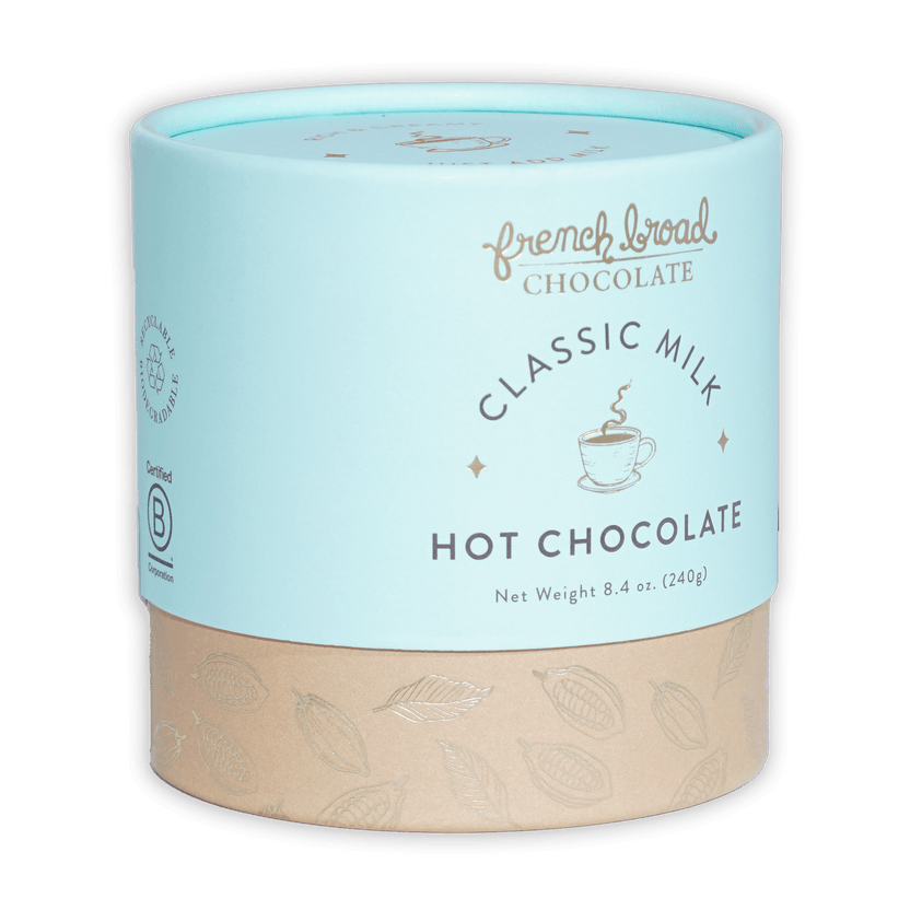 French Broad Milk Hot Chocolate Mix in light blue cylindrical can with beige base and gold leaf patterns