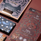 NearyNogs, Auro and Theo & Philo craft chocolate bars with illustrated wrappers on a burgundy surface