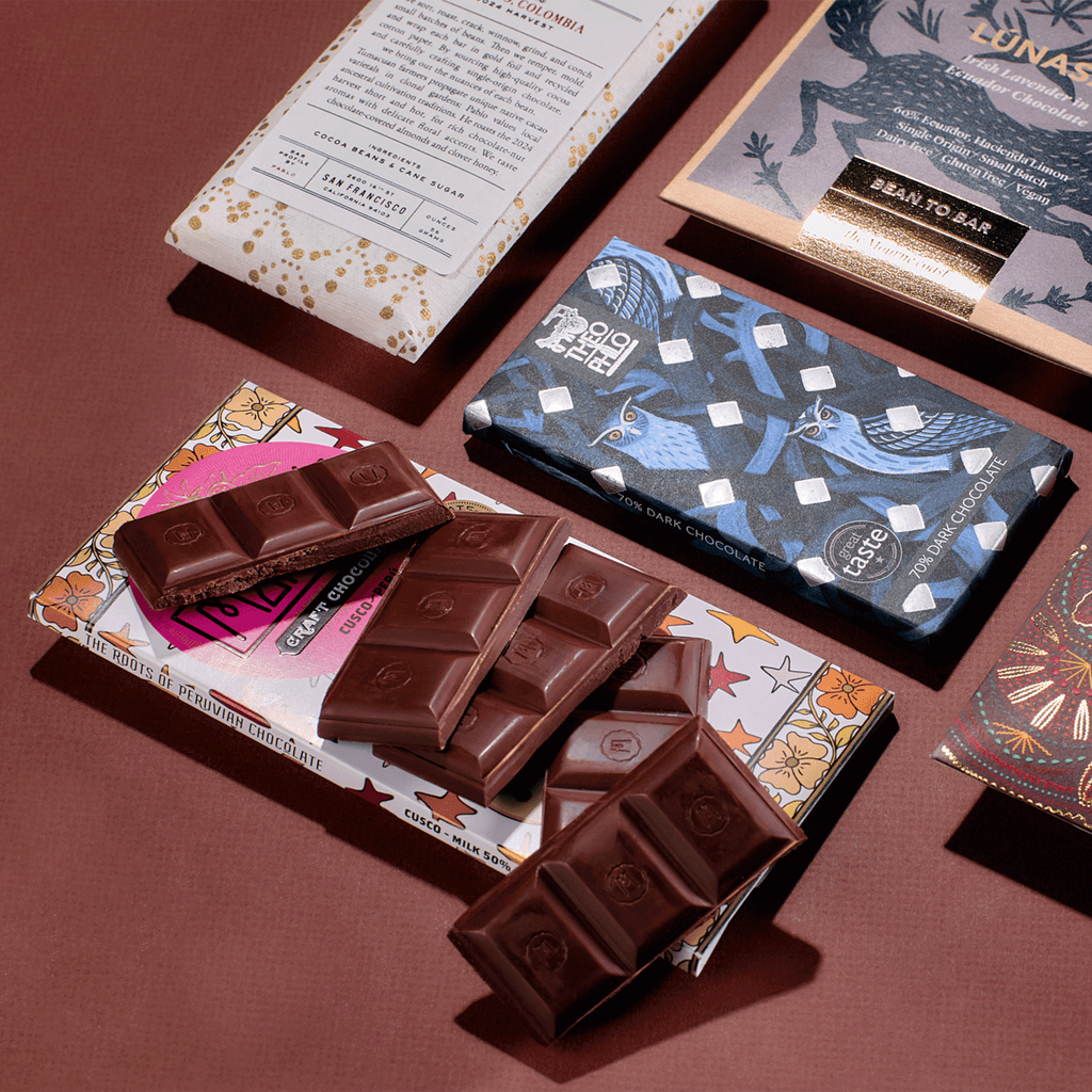 Broken dark chocolate pieces over Marana, Theo & Philo and Dandelion bars