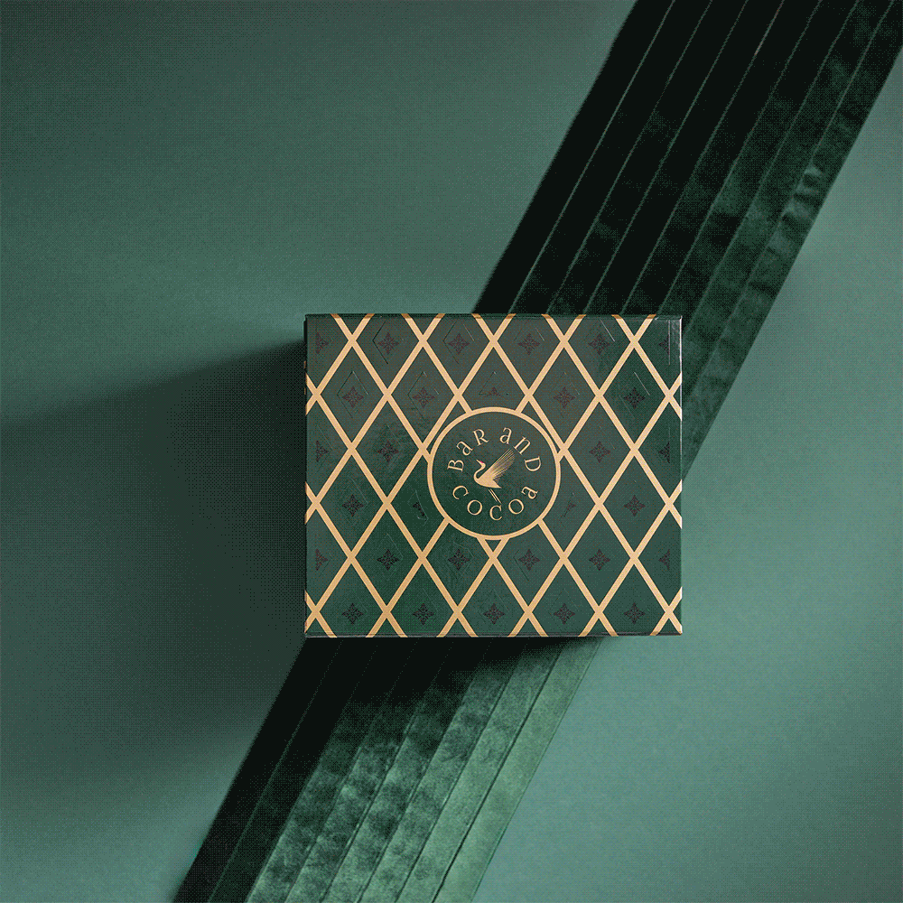 Grand Chocolate Voyage dark green box with gold lattice and eagle logo on teal velvet