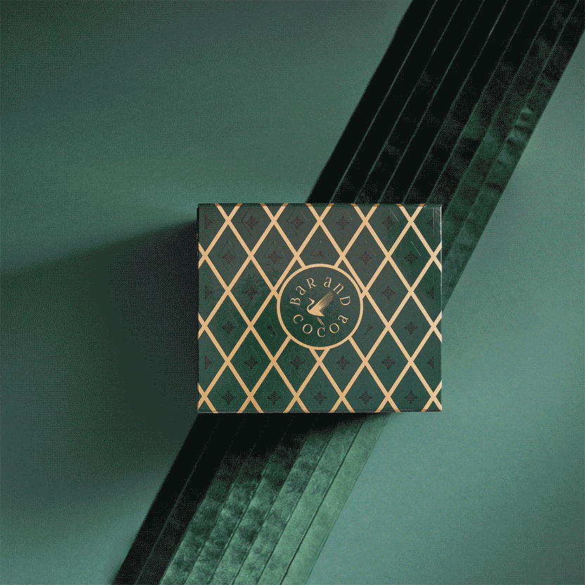 Grand Chocolate Voyage dark green box with gold lattice and eagle logo on teal velvet
