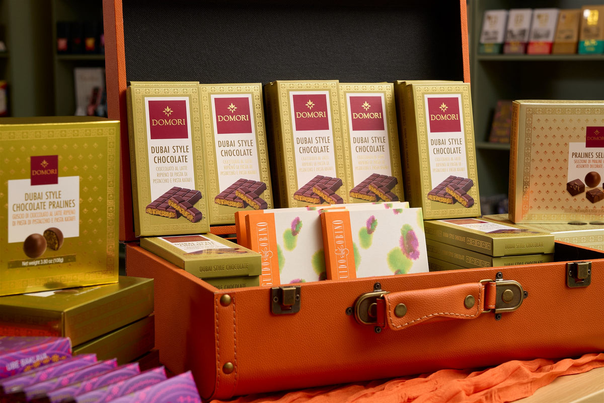 Domori chocolate bars and pralines displayed in an open orange suitcase