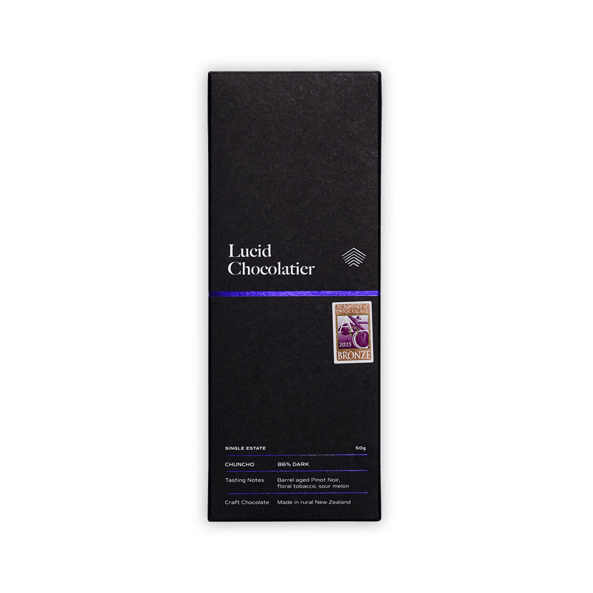 Lucid Chocolatier bar in a black box with a purple stripe and Academy of Chocolate 2025 Bronze badge, reading Single Estate, Chuncho, 86% Dark.