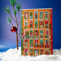 Maeve advent calendar shaped like an orange apartment building, standing in snow beside a small pine tree