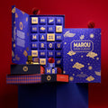 Open blue Marou advent calendar beside its gold-printed lid, with chocolate pieces and gift boxes on a red background