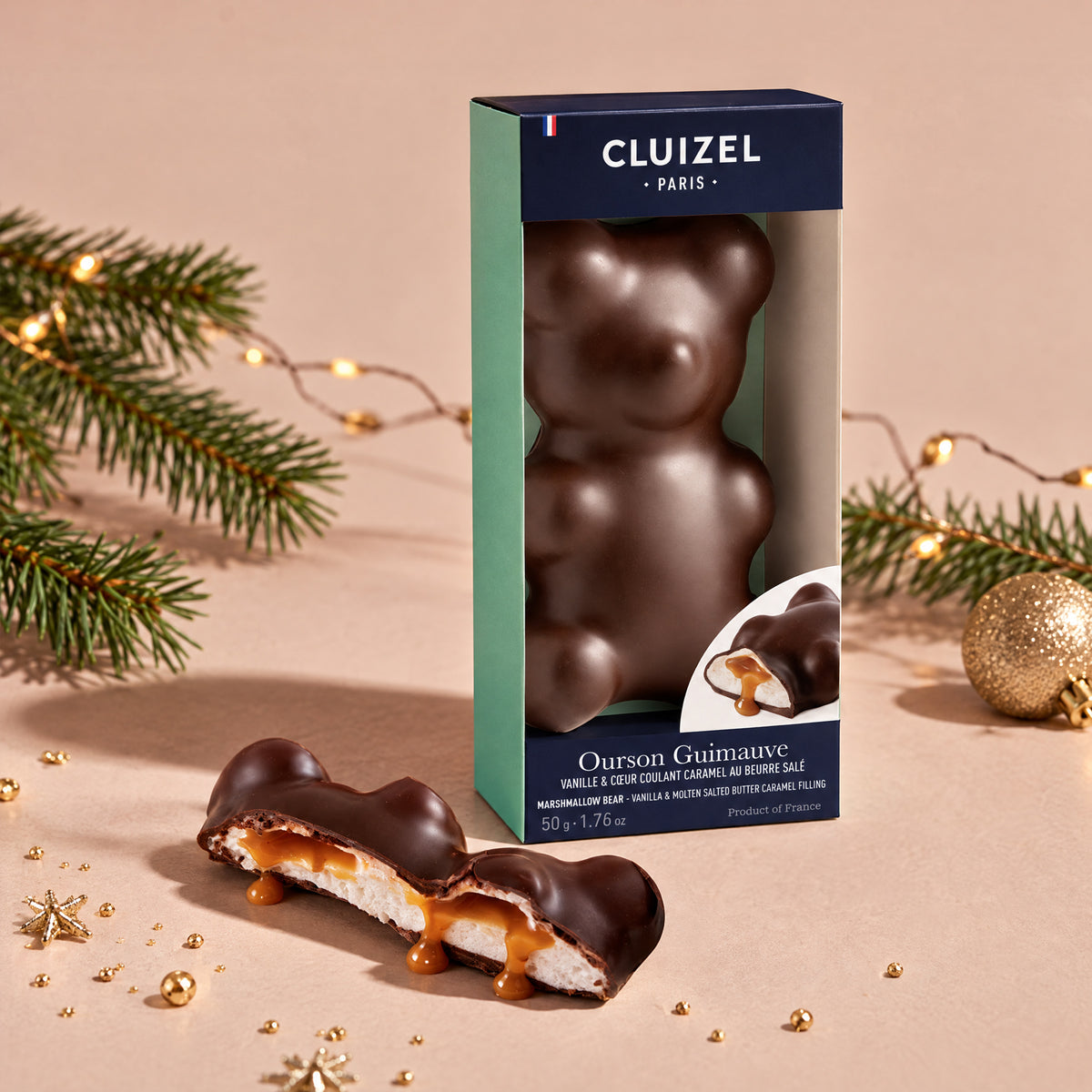 Michel Cluizel dark chocolate marshmallow bear next to its package, with one bear cut open to show the marshmallow inside.