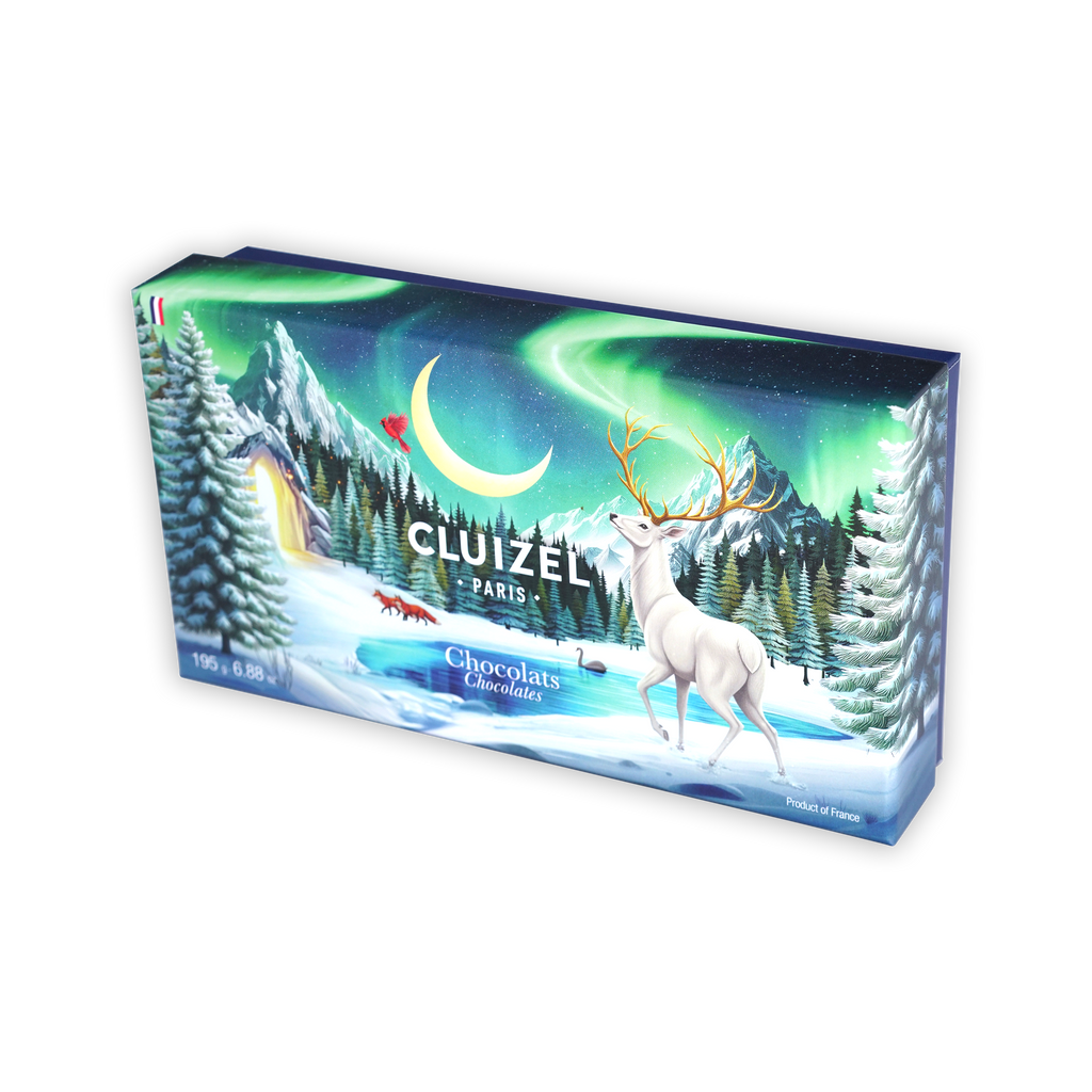 A rectangular Cluizel Paris Chocolats box showing a white stag in a snowy landscape under northern lights.