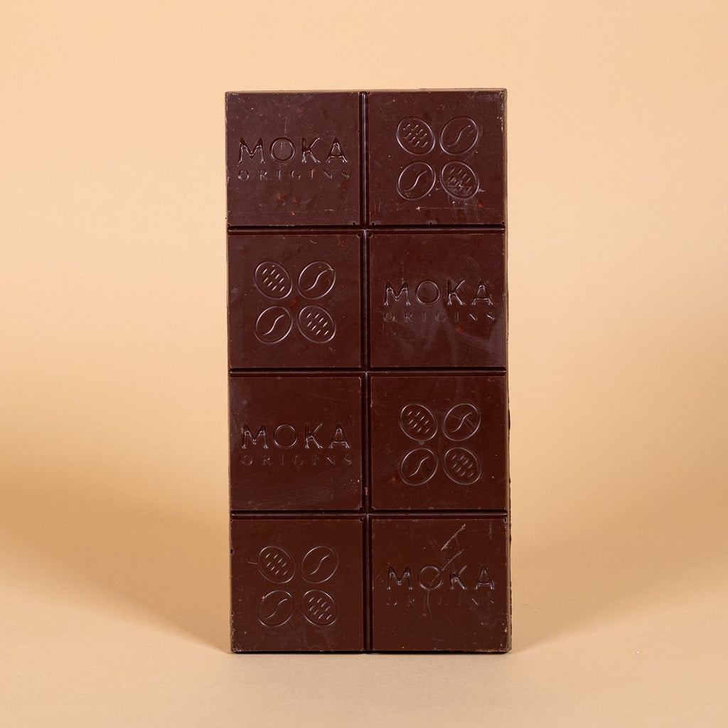 Unwrapped Moka Quinoa Crunch Milk Chocolate 58% bar on a warm beige background