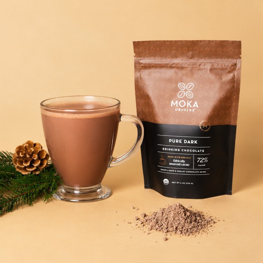 Moka Drinking Chocolate Dark 72% pouch beside a mug of prepared drinking chocolate