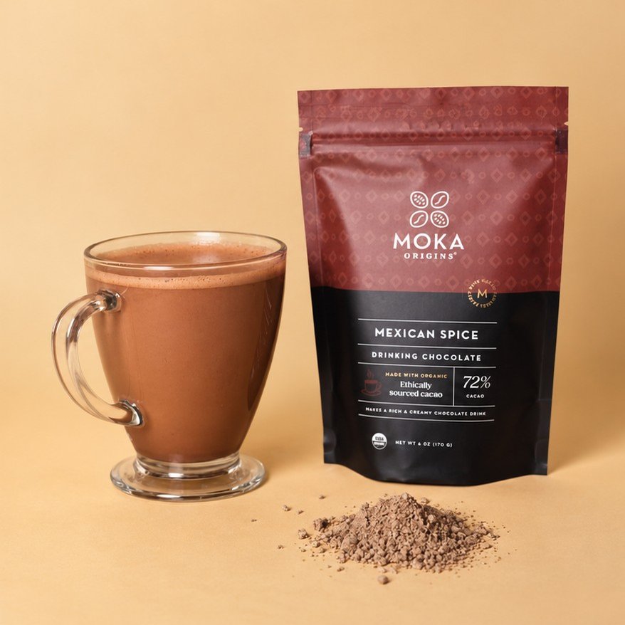 Moka Drinking Chocolate Mexican Spice 72% pouch beside a mug of prepared drinking chocolate
