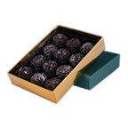 Twelve NearyNogs dark chocolate truffles arranged in an open gold box beside a green lid on a black background.