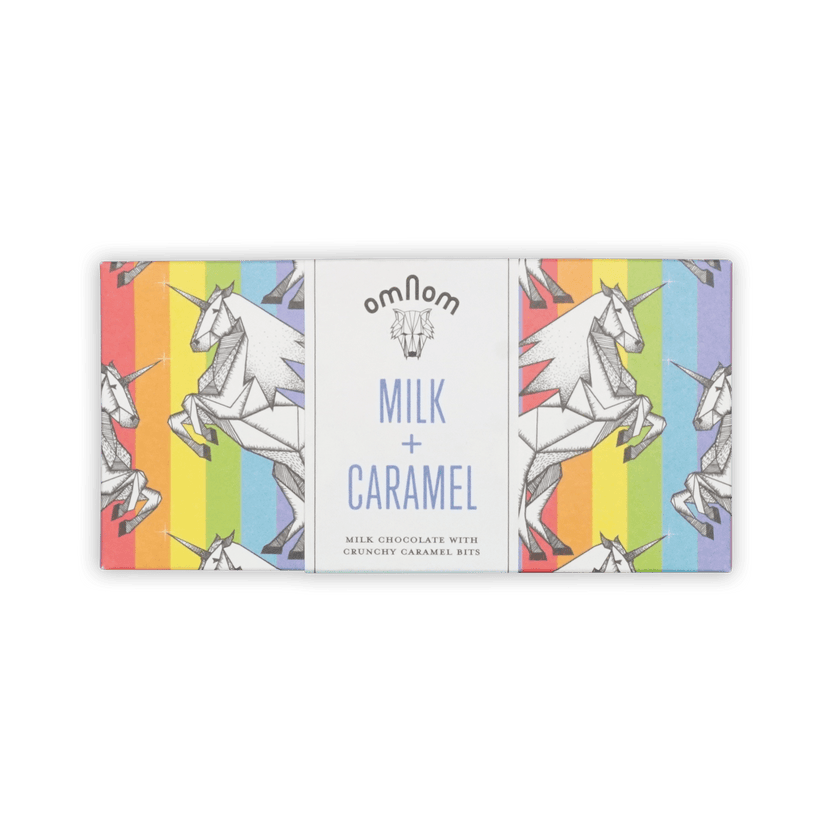 Omnom bar in rainbow-stripe wrapper with origami unicorns, white center panel reading Milk + Caramel.
