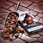 Sleek metallic scoop of cocoa beans beside Pure Chocolate Dark 84% bar
