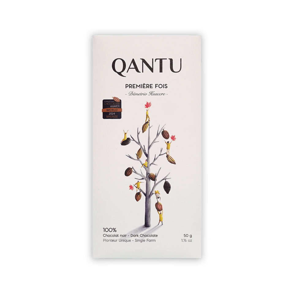 Qantu Premiere Fois 100% dark chocolate bar, cream box with an illustrated bare tree hung with cacao pods, 50g.