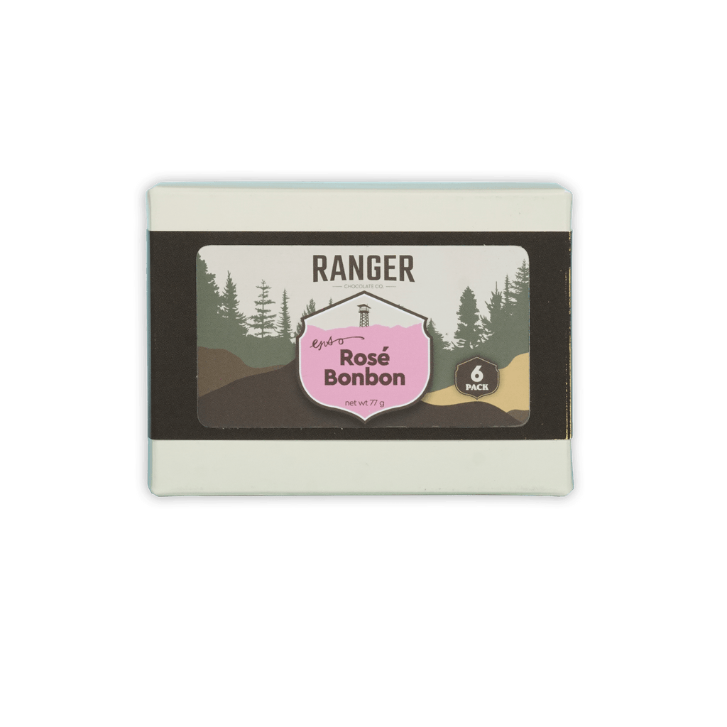 Ranger rosé bonbons box with six pink and brown candies in a white rectangular box featuring forest imagery