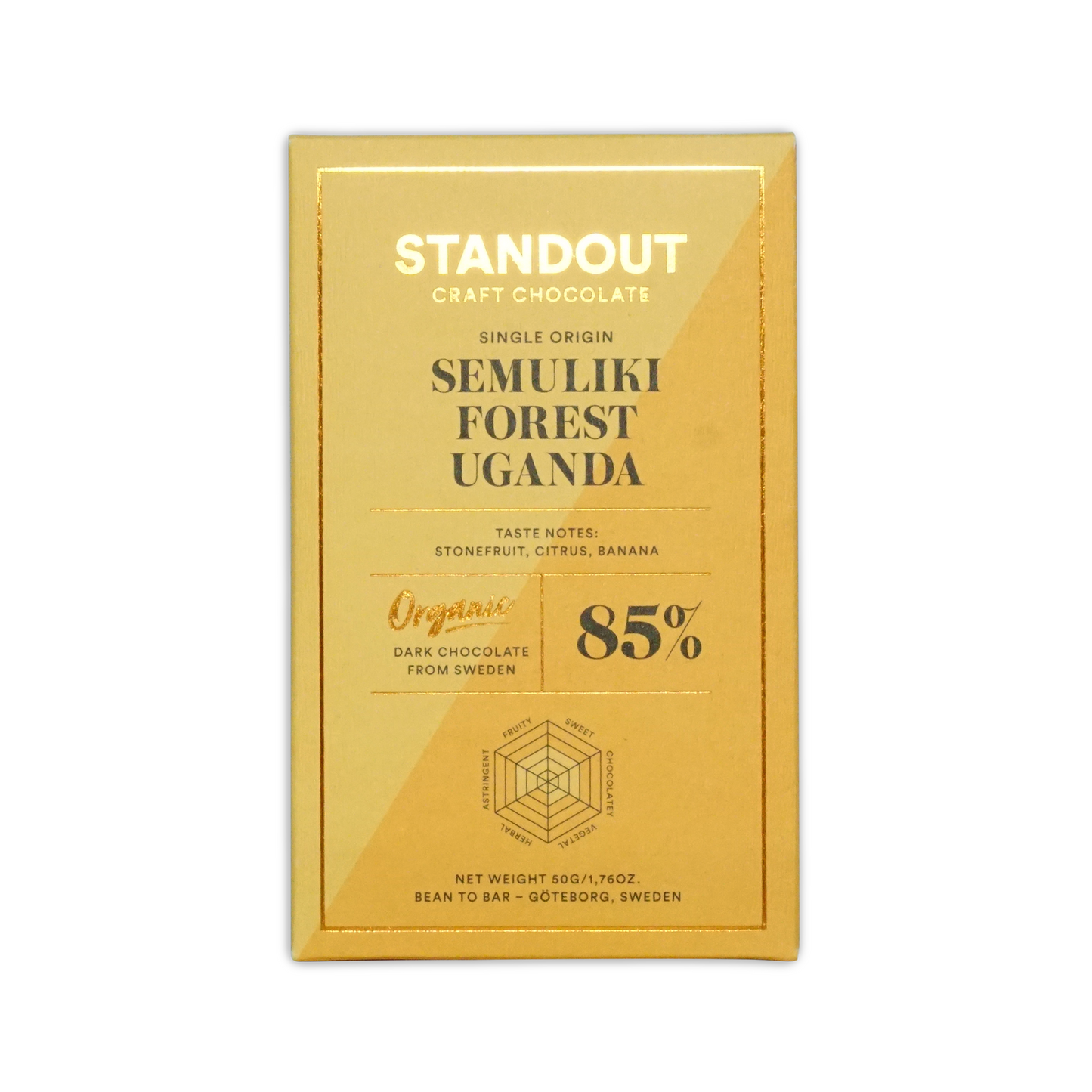 A golden-yellow rectangular chocolate bar wrapper from standout craft chocolate with gold foil lettering and a hexagonal flavor diagram for uganda semuliki forest 85 percent