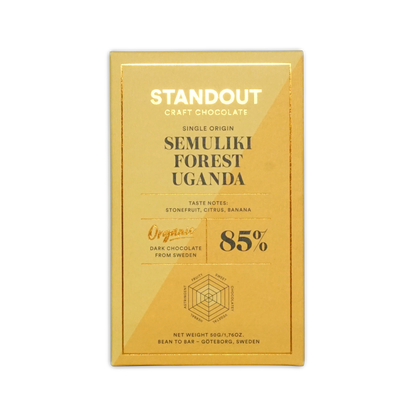 A golden-yellow rectangular chocolate bar wrapper from standout craft chocolate with gold foil lettering and a hexagonal flavor diagram for uganda semuliki forest 85 percent