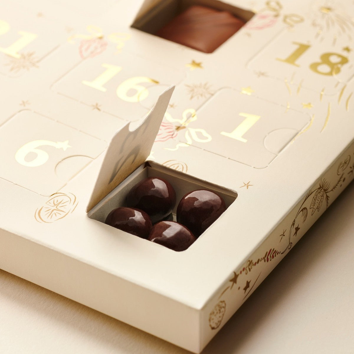 Close-up of open windows in the Valrhona 2026 Advent Calendar showing chocolate-coated nuts