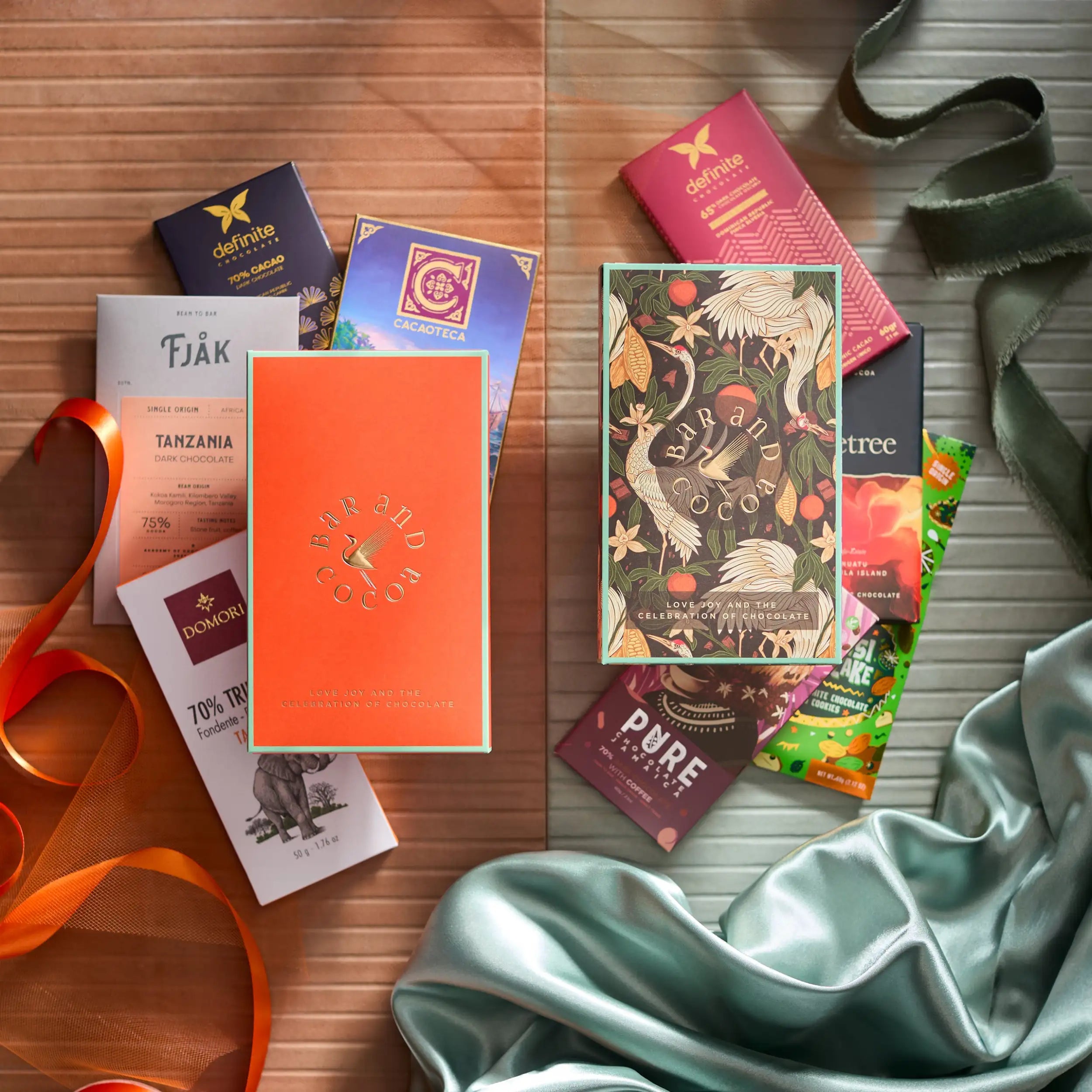 Vibrant orange rectangular chocolate bar box with gold foil lettering and a bird design