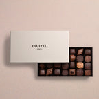 Michel Cluizel 28-piece chocolate bon bons gift box, open with assorted dark and milk chocolates