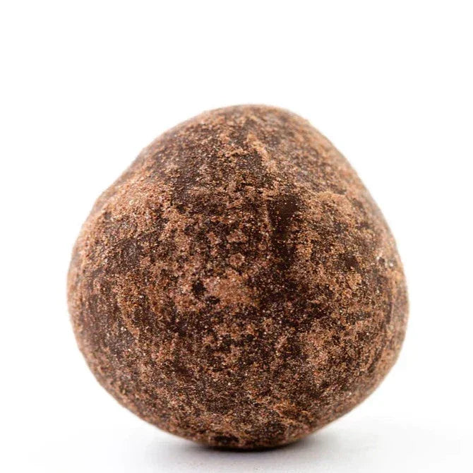 Soma dark chocolate covered hazelnut truffle, earthy-brown textured surface